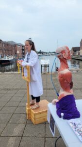 A scientist wearing a lab coat gives a talk to the public